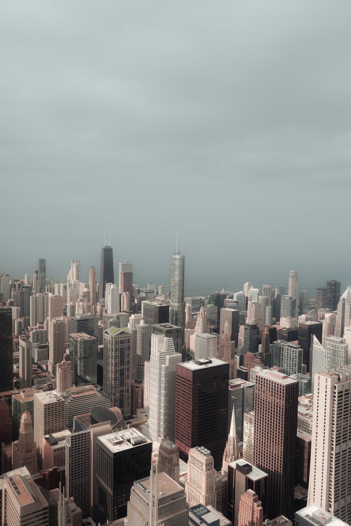 about-bg Dramatic aerial view of Chicago's iconic skyline with overcast, cloudy skies capturing the urban landscape.