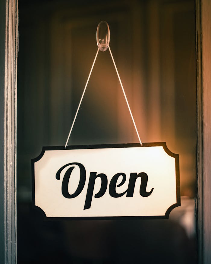services-01 Vintage 'Open' sign hanging on a shop door signifying readiness for business.